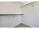 An empty walk-in closet with neutral carpet and a metal rack at 2128 S Haleyville Way, Aurora, CO 80018