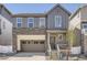 Charming two-story home with a gray exterior, stone accents, and an attached two-car garage at 2128 S Haleyville Way, Aurora, CO 80018