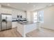 Modern kitchen with stainless steel appliances, white cabinets, a center island, and a light wood floor at 2128 S Haleyville Way, Aurora, CO 80018