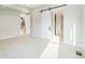 Well-lit bedroom with neutral carpet, white trim, a sliding barn door and entrance to an ensuite bathroom at 2321 Lakeshore Ln # 10, Superior, CO 80027