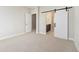 Bright, carpeted bedroom with a modern sliding barn door and doorway to the ensuite bath and closet at 2321 Lakeshore Ln # 10, Superior, CO 80027