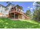 Large, landscaped backyard featuring a deck, covered patio, and lush lawn at 10822 Eagle Crest Ct, Parker, CO 80138