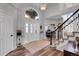 Bright foyer featuring a chandelier, hardwood floors, large window, staircase and office area beyond at 10822 Eagle Crest Ct, Parker, CO 80138