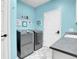 A bright laundry room features modern appliances, patterned floors, and light blue walls at 10822 Eagle Crest Ct, Parker, CO 80138