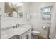 Stylish bathroom featuring marble countertops, a decorative mirror, and abundant natural light at 1870 S Ogden St, Denver, CO 80210