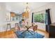Cozy dining room featuring a modern light fixture, glass top table, and views into the kitchen at 1870 S Ogden St, Denver, CO 80210