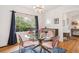 Bright dining room features a stylish glass table, plush chairs, and a window overlooking a green outdoor view at 1870 S Ogden St, Denver, CO 80210