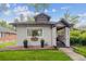 Charming home featuring a well-manicured lawn, black planters, and an inviting covered front porch at 1870 S Ogden St, Denver, CO 80210