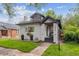 Charming house showing front yard, porch, and lush landscaping, complemented by blue skies and mature trees at 1870 S Ogden St, Denver, CO 80210