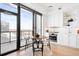 Open kitchen with white cabinets and city views, leading to a cozy dining area and a private balcony at 1750 Wewatta St # 1825, Denver, CO 80202