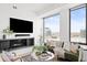Bright living room featuring a cozy fireplace, comfortable seating, and expansive windows with stunning city views at 1750 Wewatta St # 1825, Denver, CO 80202