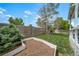 The backyard features a large green lawn with gardening beds, a wood fence, and a small pine tree at 13152 E 104Th Dr, Commerce City, CO 80022