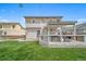The backyard features a large green lawn with a covered deck, a grill, and wood fence at 13152 E 104Th Dr, Commerce City, CO 80022