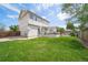 The backyard features a large green lawn with a covered deck and wood fence at 13152 E 104Th Dr, Commerce City, CO 80022