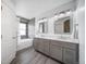 Modern bathroom with double vanity, white marble countertop, shiplap accent wall, and a shower-tub combination at 13152 E 104Th Dr, Commerce City, CO 80022