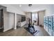 Charming bedroom featuring a wall-mounted tv, bike trainer, and shelves for organization, hard wood floors at 13152 E 104Th Dr, Commerce City, CO 80022