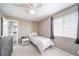 Cozy bedroom with a ceiling fan, carpet, and window providing natural light, adjoined by a bathroom at 13152 E 104Th Dr, Commerce City, CO 80022