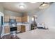 Well-equipped kitchen featuring stainless steel appliances, breakfast bar, and view to dining area at 13152 E 104Th Dr, Commerce City, CO 80022