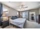 Comfortable main bedroom with a ceiling fan, bedside tables, and a large mirror reflecting a spacious interior at 13152 E 104Th Dr, Commerce City, CO 80022