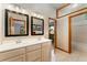 Bathroom with a double sink vanity, framed mirrors, neutral tile flooring, and an adjoined shower/tub at 3933 W 102Nd Ave, Westminster, CO 80031