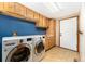 Convenient laundry room features front loading washer and dryer, blue wall and built in cabinets at 3933 W 102Nd Ave, Westminster, CO 80031