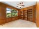 Bright study features wood paneled walls, a built-in bookcase, neutral carpet, and a large window at 3933 W 102Nd Ave, Westminster, CO 80031