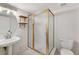 Bright bathroom with a frosted glass shower, vessel sink, wood shelves, and tiled floor at 13025 W 63Rd Pl # C, Arvada, CO 80004