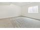 This basement features a cozy carpet, a bright window, and ample space at 5726 N Jebel Way, Aurora, CO 80019