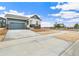 Single-Gathering home featuring blue siding, stone accents, and a two-car garage on a large, paved lot at 5726 N Jebel Way, Aurora, CO 80019