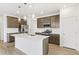 Modern kitchen features stainless appliances, a large island, and stylish pendant lighting at 5726 N Jebel Way, Aurora, CO 80019