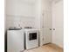 Functional laundry room with modern washer and dryer and overhead shelving at 5726 N Jebel Way, Aurora, CO 80019