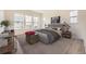 A well-lit bedroom featuring light gray walls, a large bed, and several windows at 11452 Autumn Moon St, Littleton, CO 80125
