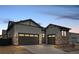 View of the home's gray exterior featuring a driveway with a 3-car garage at 11452 Autumn Moon St, Littleton, CO 80125