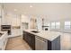 Bright kitchen showcasing a center island with sink, white cabinets, and stainless steel appliances at 11452 Autumn Moon St, Littleton, CO 80125