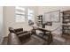 Comfortable home office space featuring a modern desk, leather chairs, and natural light from the windows at 11452 Autumn Moon St, Littleton, CO 80125