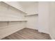 A walk-in closet with light gray wood flooring, shelving and white walls at 11452 Autumn Moon St, Littleton, CO 80125