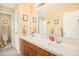 Bathroom with double sinks, wooden cabinets, and decorative wall art at 23453 Painted Hills St, Parker, CO 80138