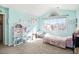 A bedroom with light blue walls and a large window letting in lots of natural light at 23453 Painted Hills St, Parker, CO 80138