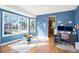 Bright living space with blue walls, hardwood floors, large windows, and natural light at 23453 Painted Hills St, Parker, CO 80138