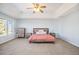 Bright main bedroom offers ample space, plush carpet, a ceiling fan and beautiful natural light from large windows at 23453 Painted Hills St, Parker, CO 80138