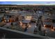Luxury home at dusk, showcasing the architectural design and community layout with city lights and mountain views at 9487 Winding Hill Way, Lone Tree, CO 80124