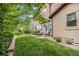 Landscaped backyard featuring a brick patio with seating, a large yard, and mature trees at 9487 Winding Hill Way, Lone Tree, CO 80124