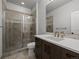 Beautiful bathroom featuring a tiled glass shower, dark cabinets, and a white quartz countertop at 9487 Winding Hill Way, Lone Tree, CO 80124