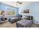 Bright bedroom featuring two twin beds, blue walls and light from two large windows at 9487 Winding Hill Way, Lone Tree, CO 80124