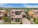 Beautiful tile roof on a tan two-story home with stone accents, a brick driveway, and mountain views in the distance at 9487 Winding Hill Way, Lone Tree, CO 80124