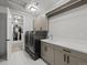 Well-equipped laundry room with modern washer and dryer, sink, and storage cabinets at 9487 Winding Hill Way, Lone Tree, CO 80124