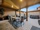 Covered patio featuring a dining table, an outdoor kitchen, and additional seating with a hot tub at 9487 Winding Hill Way, Lone Tree, CO 80124
