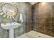 Chic bathroom featuring unique wallpaper, pedestal sink, and glass-enclosed shower at 410 Acoma St # 309, Denver, CO 80204