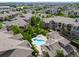 An aerial view showcases community pool, hot tub, surrounding townhouses, and lush green landscaping at 10787 Twenty Mile Rd # 205, Parker, CO 80134