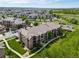 An aerial view of a condo complex with manicured lawns, lush trees, and parking for residents at 10787 Twenty Mile Rd # 205, Parker, CO 80134